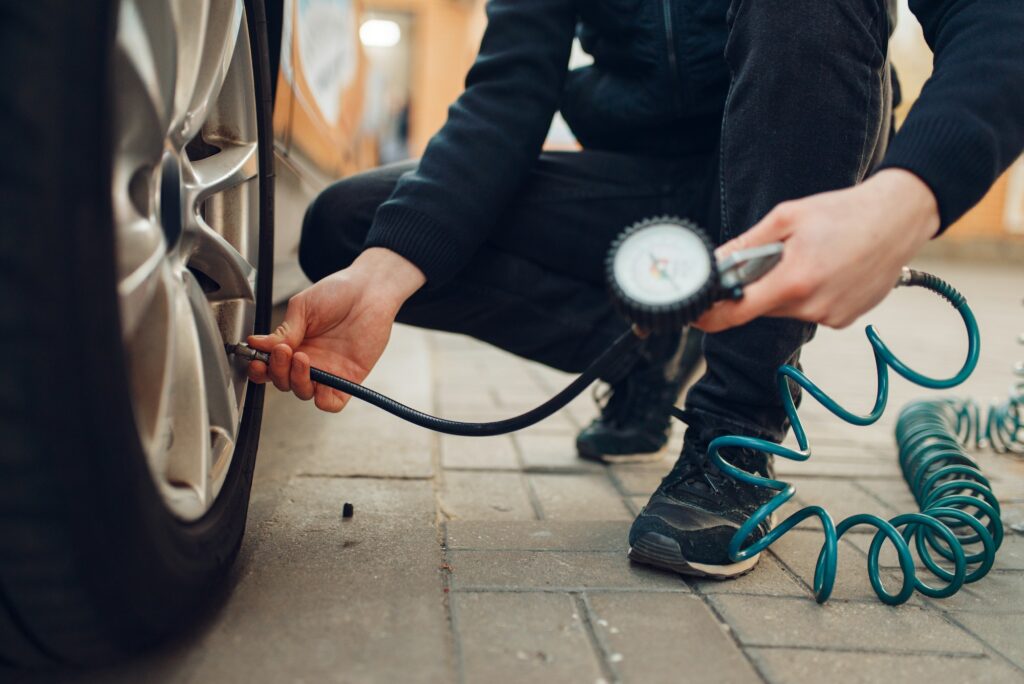 Male person checks the tire pressure, tyre service